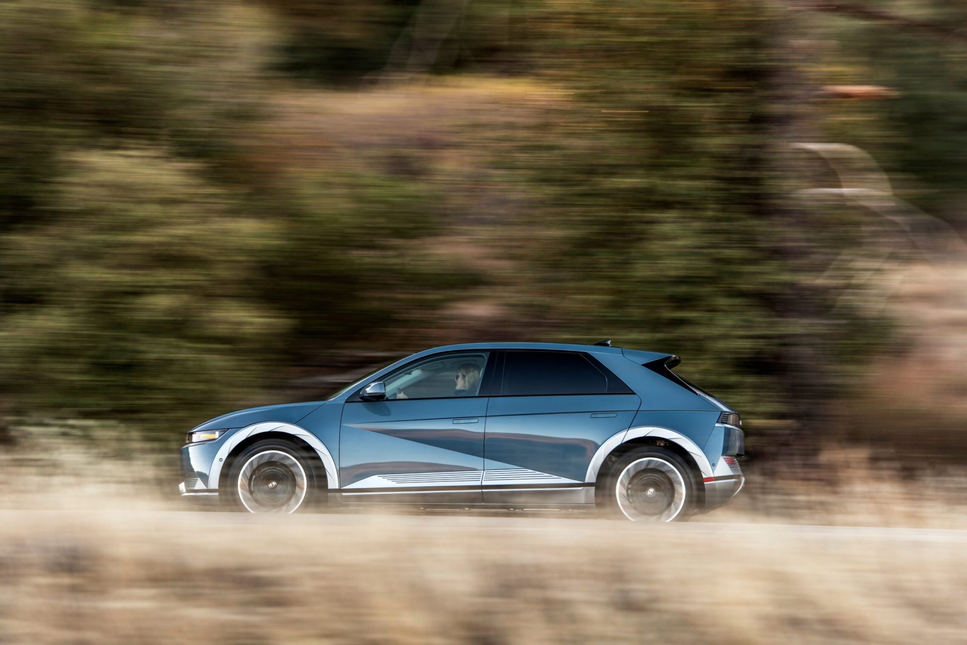 La Hyundai Ioniq 5 qui roule sur une route au bord de la forêt
