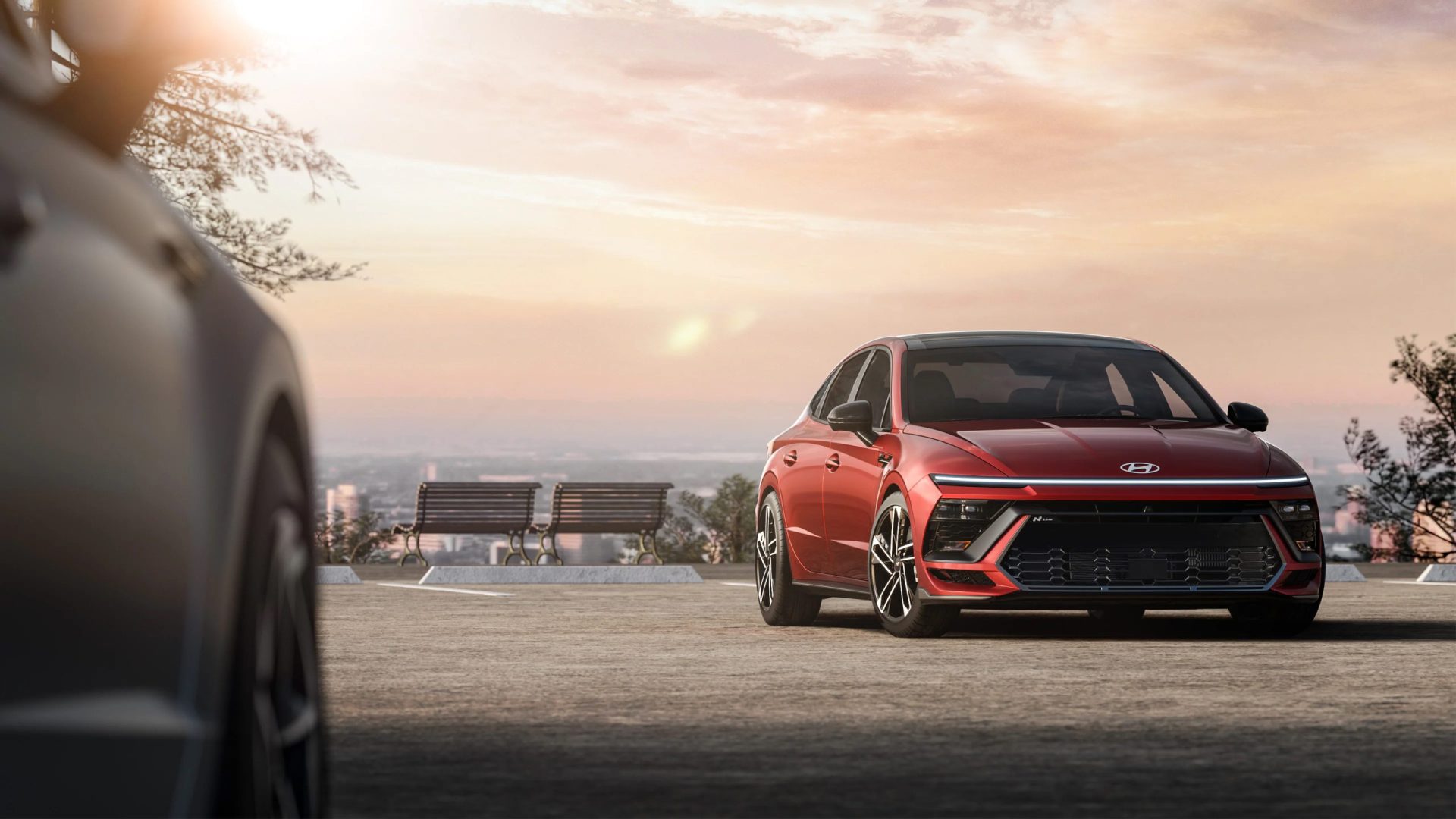 La berline Hyundai Sonata 2025 stationnée avec en arrière plan des bancs et la ville.